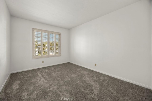 carpeted spare room with baseboards