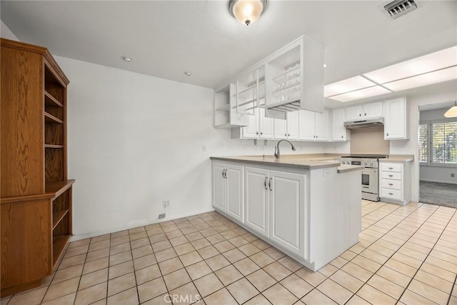 kitchen with visible vents, a peninsula, high end stainless steel range oven, under cabinet range hood, and open shelves