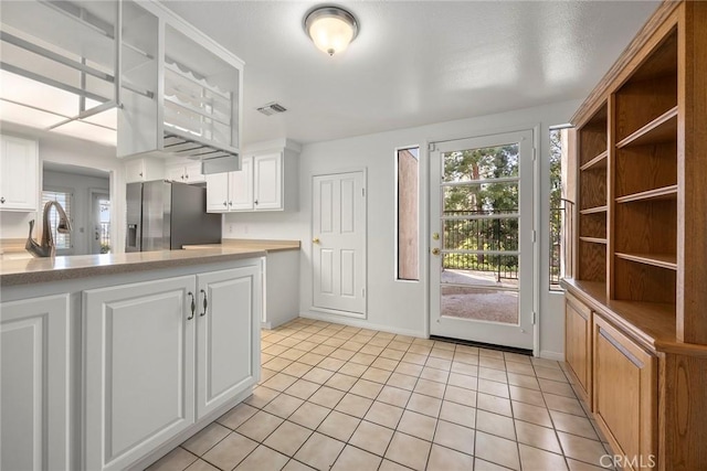 kitchen with plenty of natural light, stainless steel fridge, visible vents, and a sink