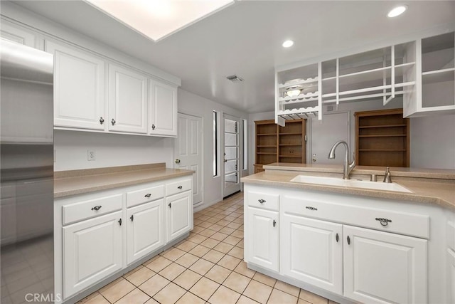 kitchen featuring visible vents, white cabinets, light countertops, a sink, and recessed lighting