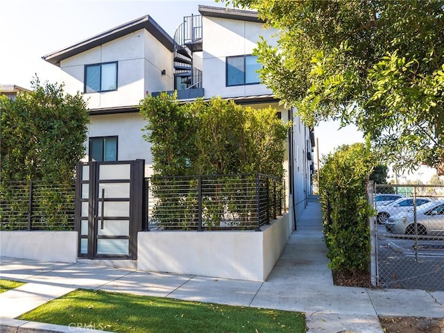 contemporary home featuring fence, a gate, and stucco siding