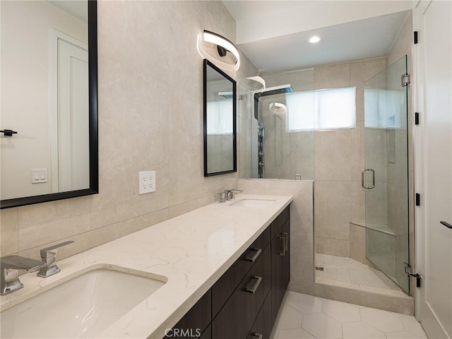 bathroom featuring double vanity, a stall shower, tile patterned flooring, and a sink