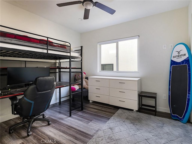 bedroom with a ceiling fan, baseboards, and wood finished floors