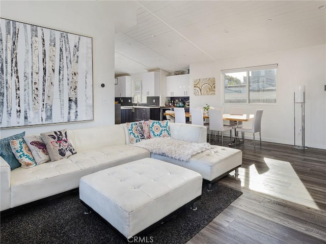 living room with lofted ceiling, baseboards, and wood finished floors