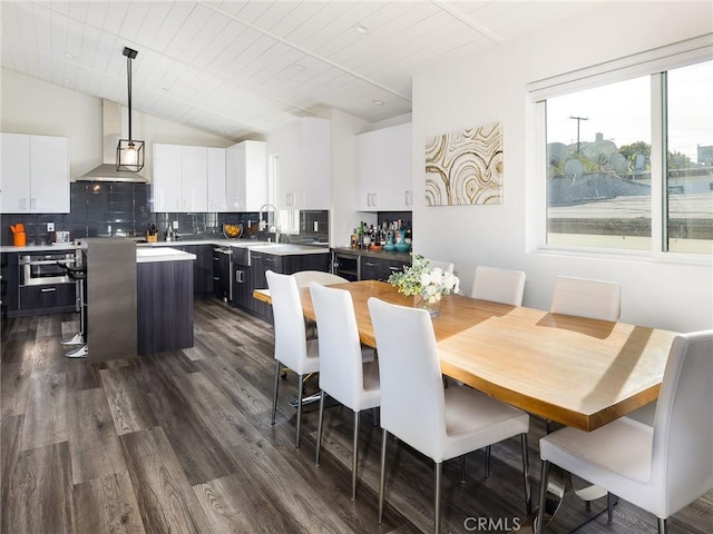 dining area featuring lofted ceiling and dark wood finished floors