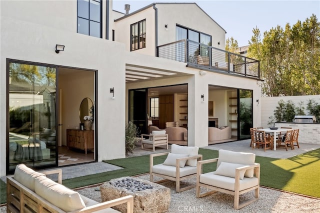 exterior space with a balcony, an outdoor hangout area, stucco siding, and a patio area