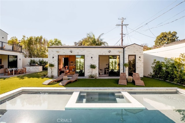 rear view of property with a patio area, a yard, and a balcony