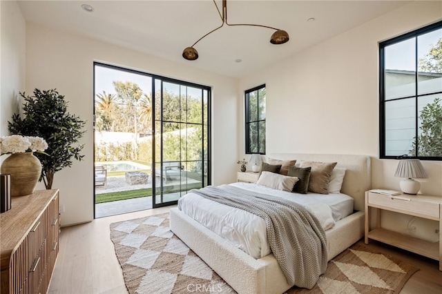 bedroom featuring light wood-style floors and access to outside