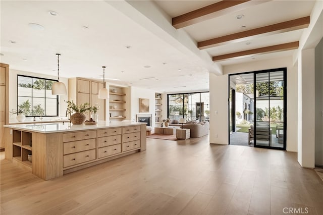 kitchen featuring light brown cabinets, light countertops, light wood-style flooring, and open shelves