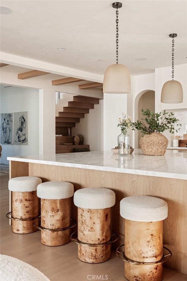 bar featuring decorative light fixtures and wood finished floors