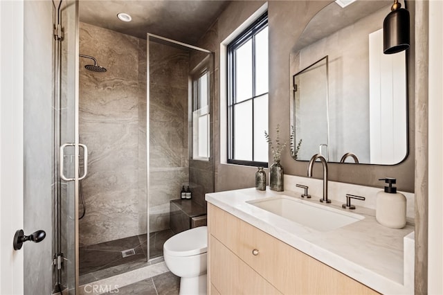 bathroom with a shower stall, toilet, and a healthy amount of sunlight