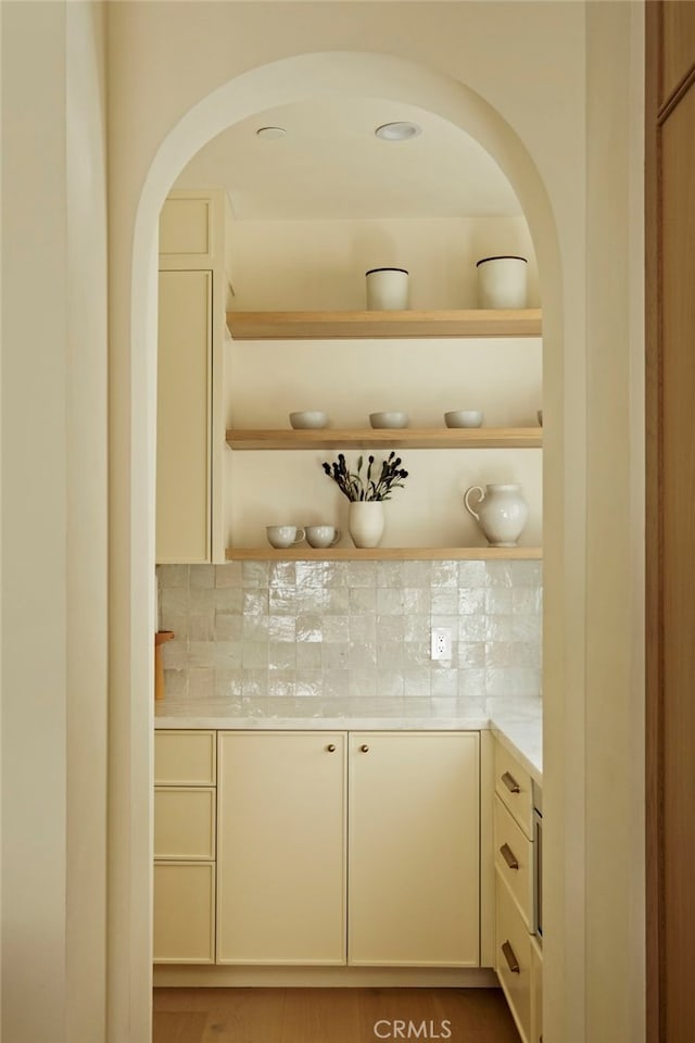 bar with arched walkways, a dry bar, and decorative backsplash