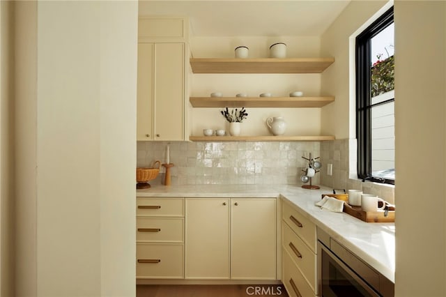 kitchen with backsplash, stainless steel microwave, and open shelves