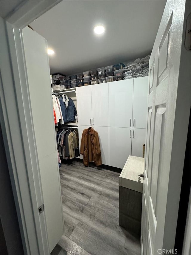 walk in closet with wood finished floors