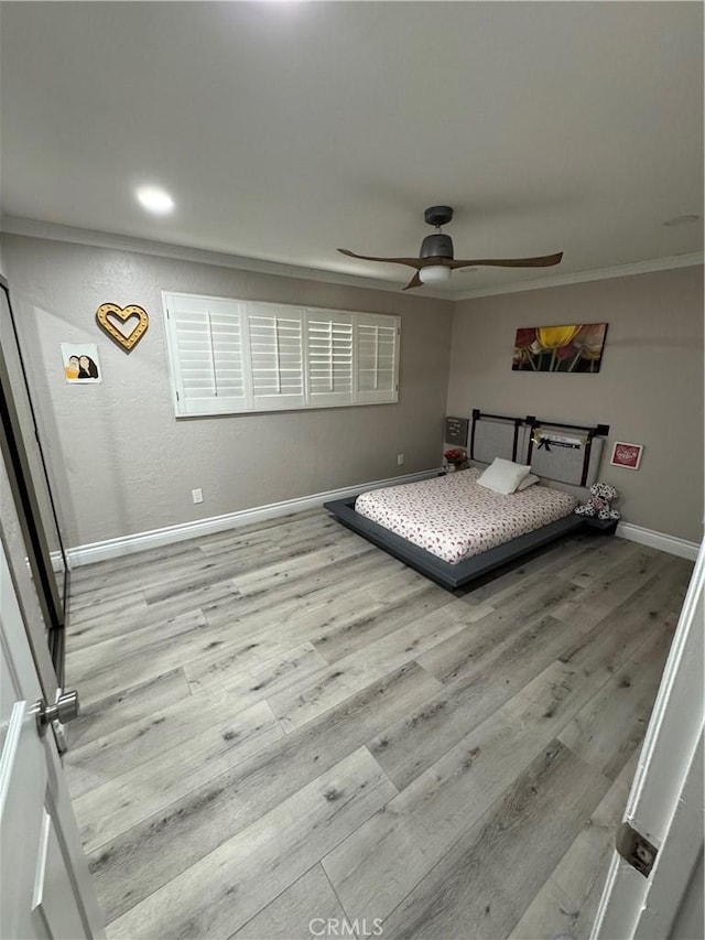 unfurnished bedroom with ornamental molding, wood finished floors, and baseboards