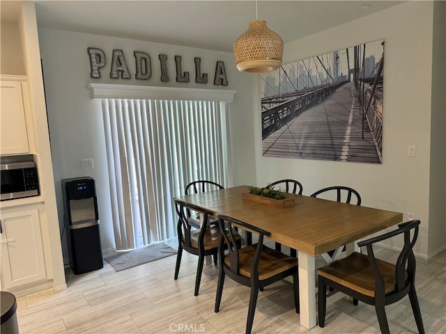 dining room featuring baseboards and light wood finished floors