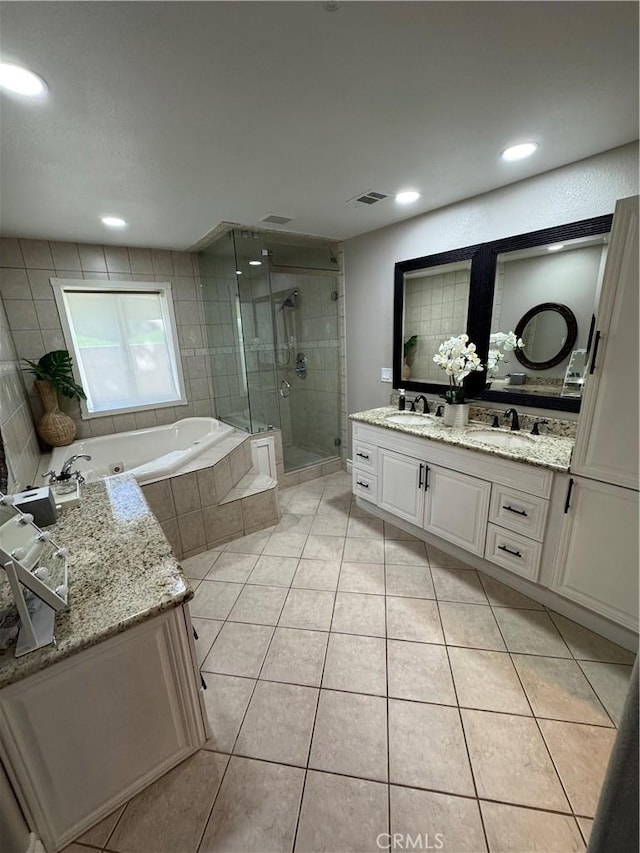 full bath with double vanity, a sink, a shower stall, tile patterned flooring, and a whirlpool tub