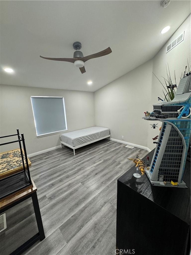 bedroom featuring baseboards, visible vents, a ceiling fan, and wood finished floors