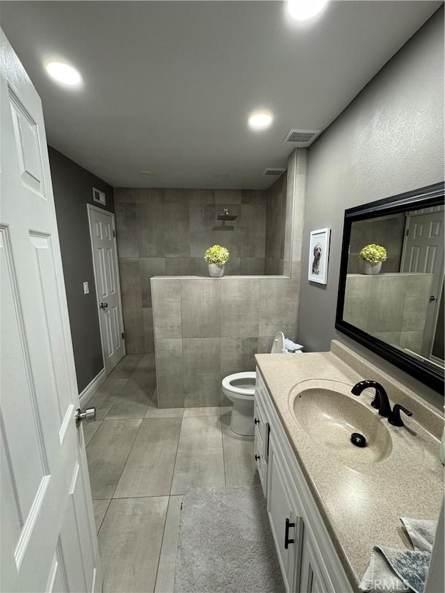 full bath with visible vents, vanity, toilet, and a walk in shower