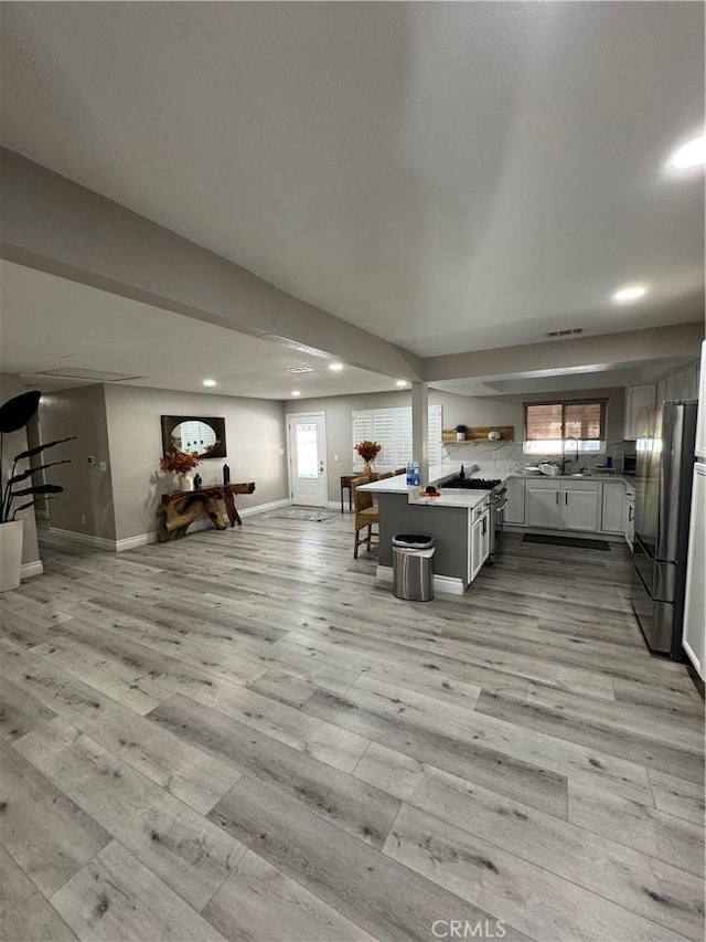 living room featuring recessed lighting, visible vents, light wood-style flooring, and baseboards