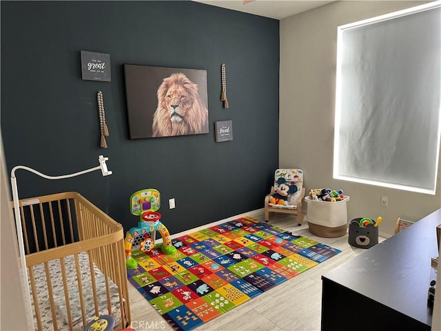 bedroom with a nursery area and baseboards