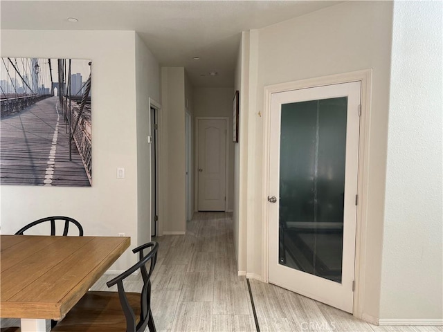 dining space with light wood-type flooring and baseboards