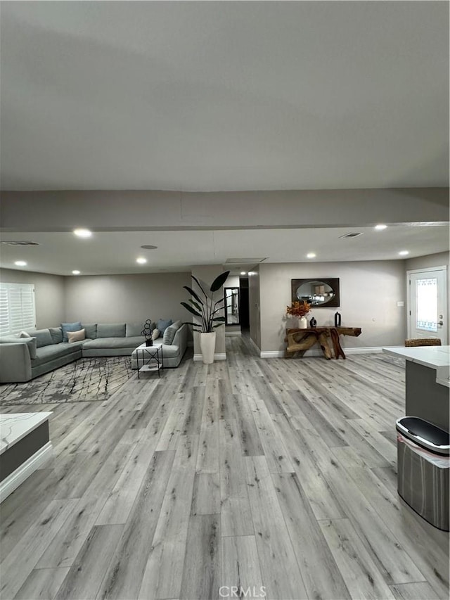 unfurnished living room featuring light wood-type flooring, baseboards, and recessed lighting