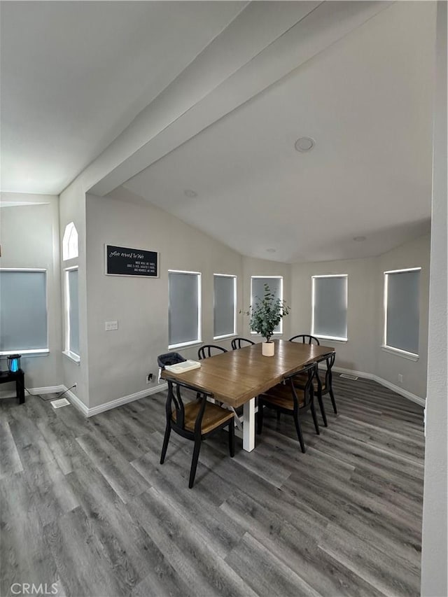 dining area with vaulted ceiling, baseboards, and wood finished floors