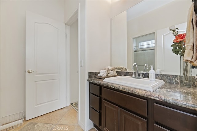 full bathroom featuring tile patterned floors, a shower with shower door, and vanity