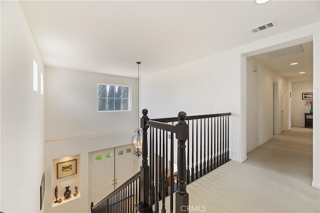 hallway with recessed lighting, visible vents, an upstairs landing, and carpet flooring