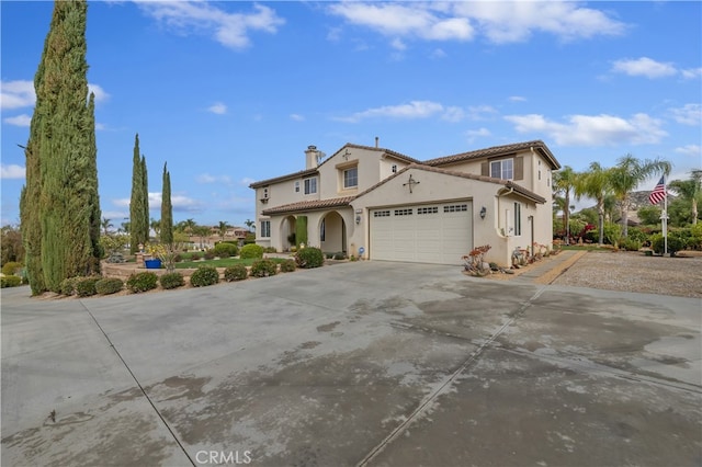 mediterranean / spanish-style house with a garage, a chimney, driveway, and stucco siding