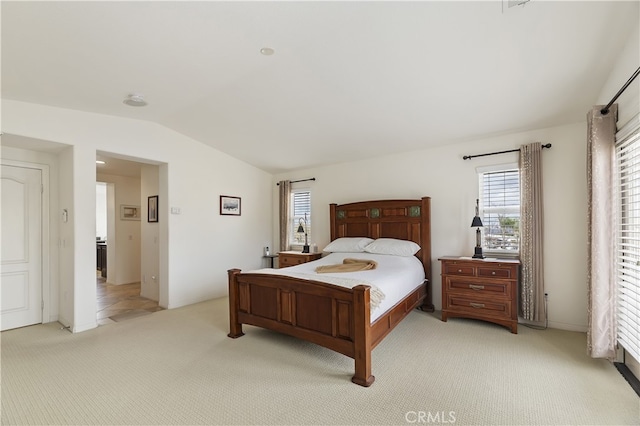 bedroom with vaulted ceiling and light colored carpet