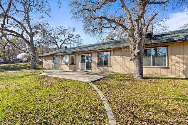 rear view of property with a yard and a patio