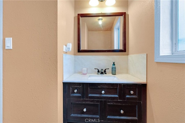 bathroom featuring vanity and decorative backsplash