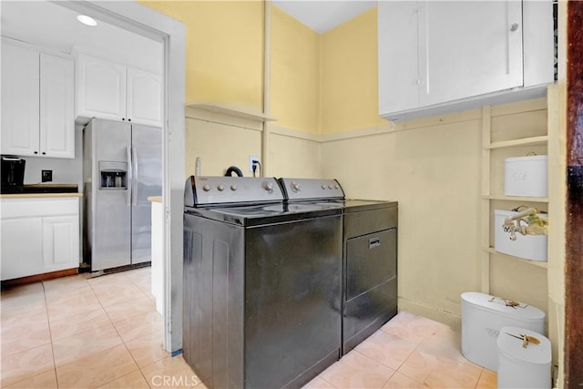 laundry area with cabinet space, independent washer and dryer, and light tile patterned floors