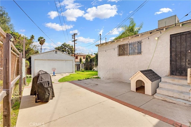 exterior space with a garage, an outbuilding, and fence