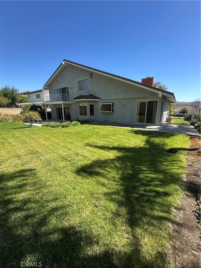 rear view of property featuring a lawn