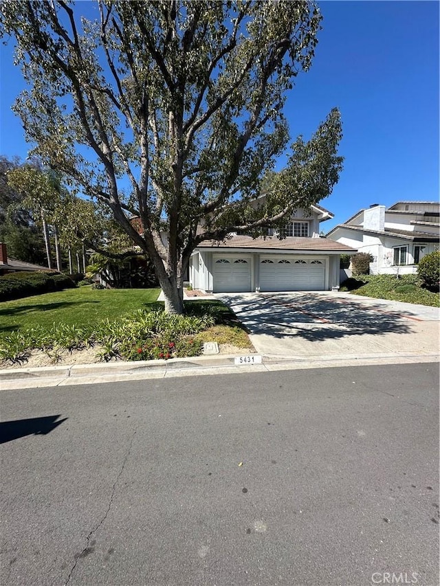 view of front of home featuring driveway, a garage, and a front yard