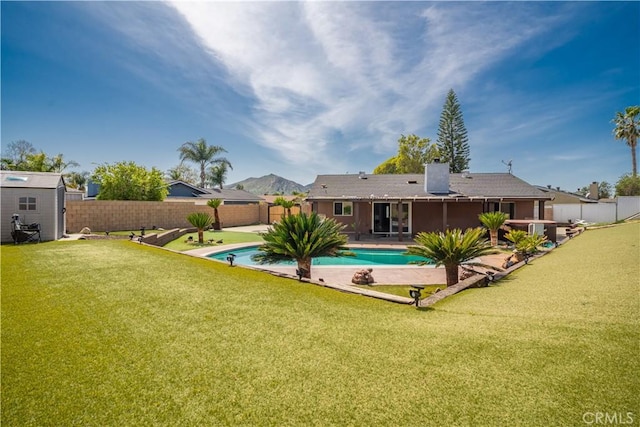 18218 Otilla St, Bloomington, CA 92316 - rear view of property featuring a patio area, a fenced in pool, a fenced backyard, and a lawn