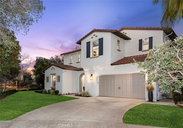 mediterranean / spanish home featuring a tile roof, stucco siding, a garage, driveway, and a front lawn