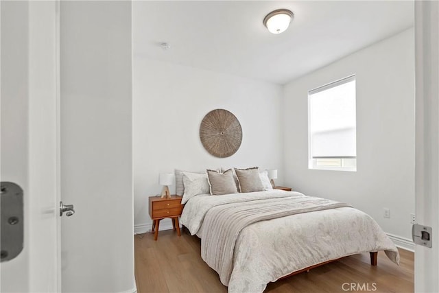 bedroom featuring baseboards and light wood-type flooring