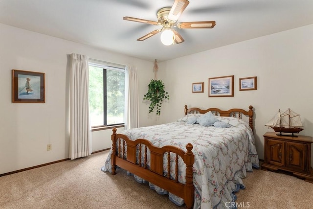 carpeted bedroom with ceiling fan and baseboards