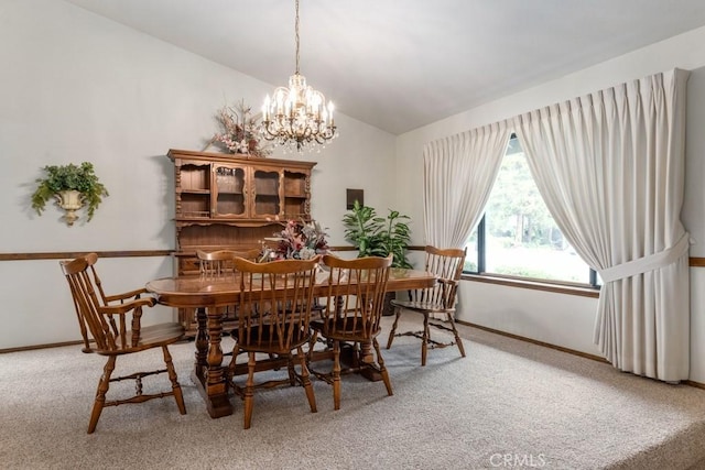 dining area with lofted ceiling, carpet, baseboards, and a notable chandelier