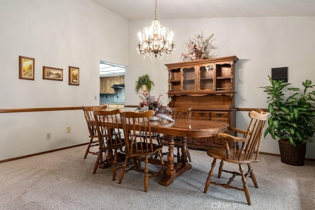 carpeted dining area with an inviting chandelier, a high ceiling, and baseboards