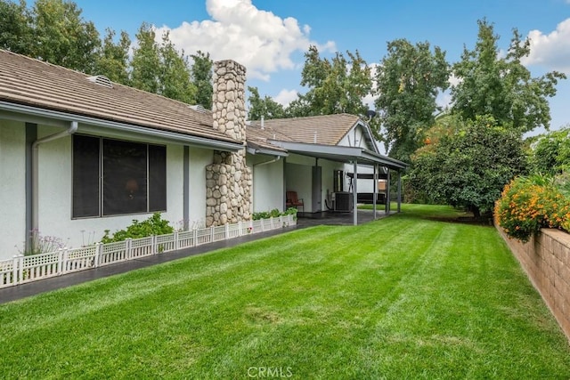 back of property featuring a lawn, a chimney, fence, and stucco siding