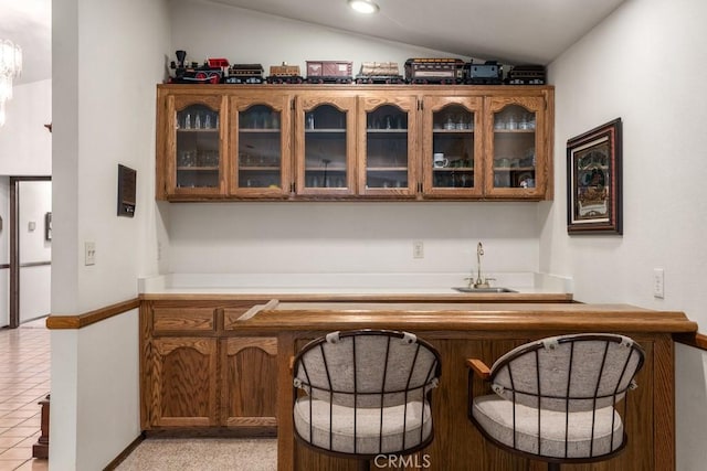 bar with light tile patterned floors, a sink, vaulted ceiling, indoor wet bar, and recessed lighting