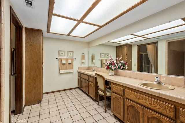 bathroom featuring double vanity, tile patterned flooring, a sink, and visible vents