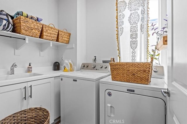 laundry room with cabinet space, washer and clothes dryer, and a sink