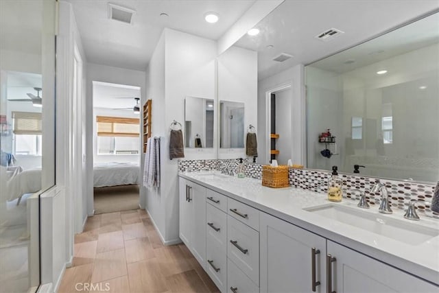 bathroom featuring ceiling fan, visible vents, a sink, and ensuite bathroom