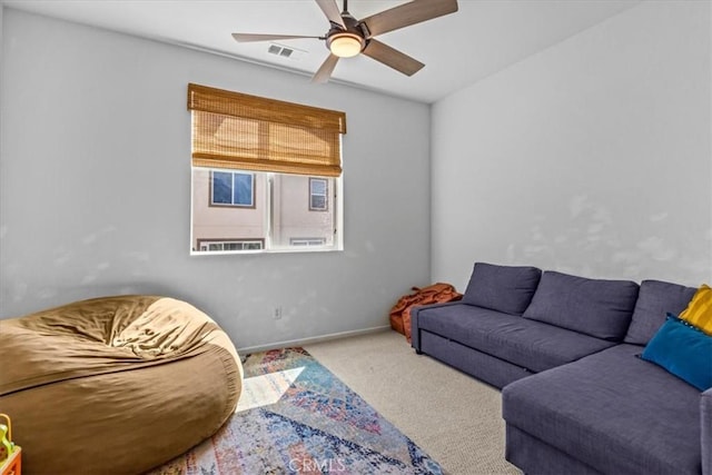 carpeted living area featuring a ceiling fan, visible vents, and baseboards